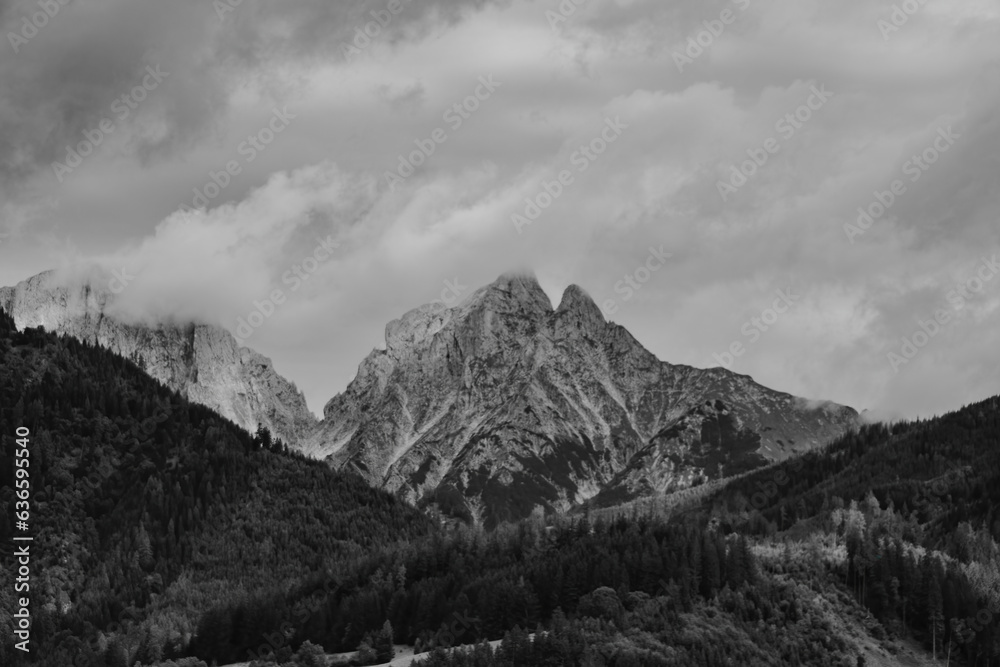 Fototapeta premium Alps mountains in clouds, black and white