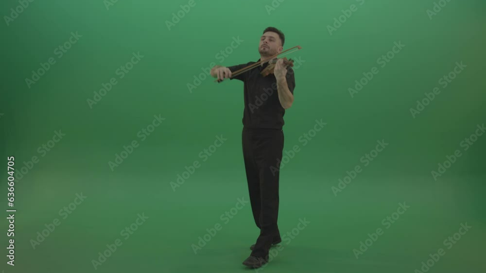 Young Man in black costume play violin fiddle strings music instument and move on isolated green screen Young Man in black costume play violin fiddle strings music instument and move on isolated green screen