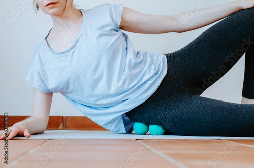 Woman doing gluteus self massage with therapy balls 