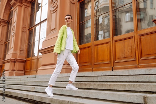 Stylish young woman with short haircut posing on city streets. Cheerful woman walks, enjoys the sunny weather. The concept of fashion, style. photo