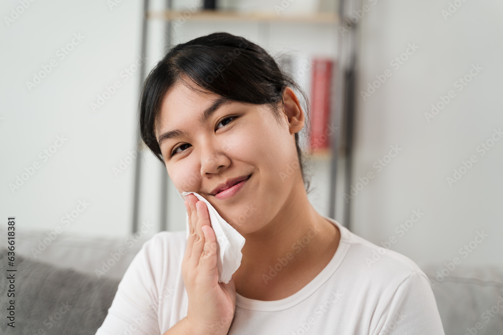 Young Asian woman wiping face with paper towel, Facial Cleansing Wipes, Removing Makeup. Beauty and fashion concept. Young Asian woman wiping face with paper towel, Facial Cleansing Wipes, Removing Makeup. Beauty and fashion concept.