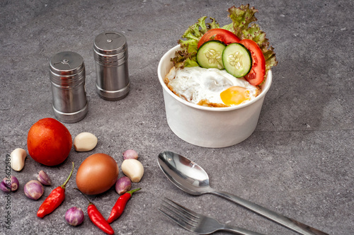 Posiłek na stole składający się z dania na wynos: rice bowl z ryżem, jajkiem i warzywami