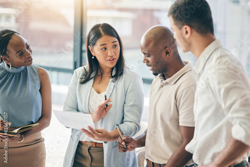 Meeting, business people with woman boss and paperwork for training, motivation and collaboration. Teamwork, men and women in office with documents, feedback and brainstorming at workshop with mentor