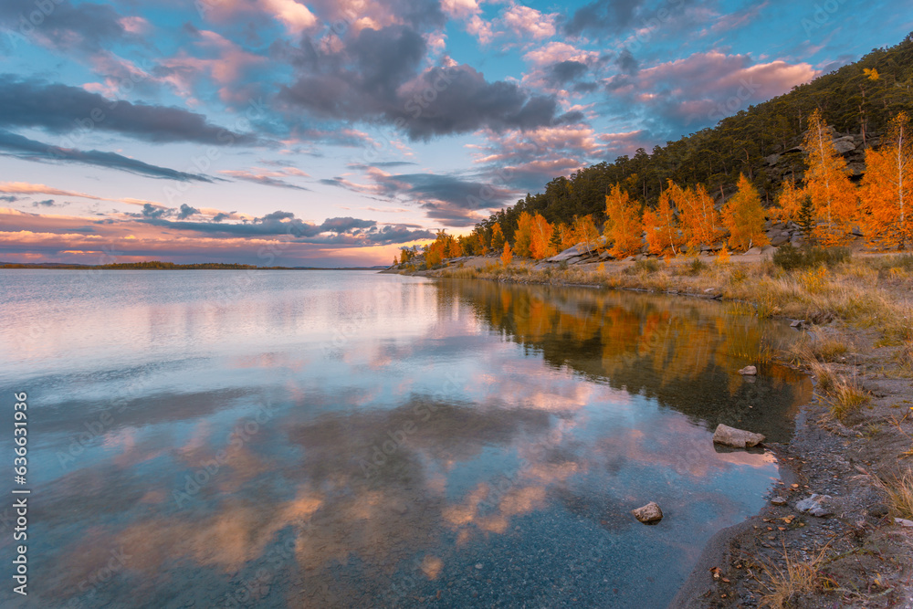 Autumn evening gorgeous cloudscape. The bright colors of autumn around the lake. Kazakhstan. Burabay. Asia.
