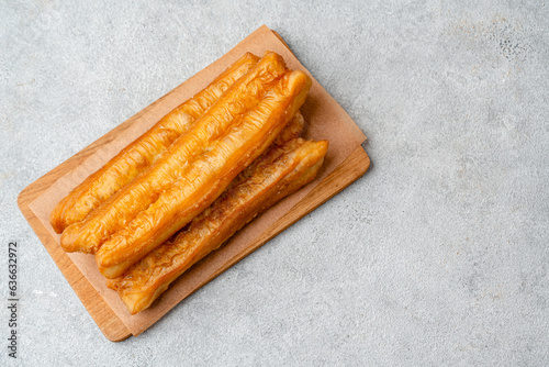 Youtiao or Yu Char Kway is a long golden-brown deep-fried strip of wheat flour dough of Chinese origin photo