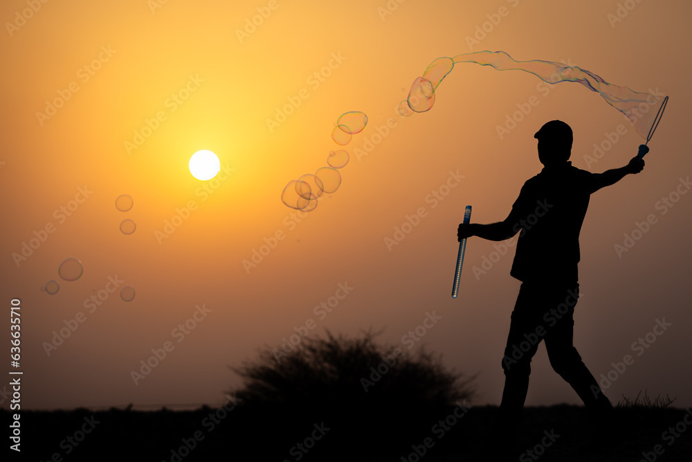 silhouette of a man blowing bubbles