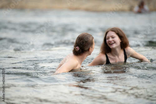 Young couple having fun in the water of a river on a hot summer day