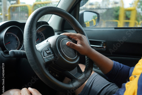 man holding steering wheel of car, black man driving car  © Aniket