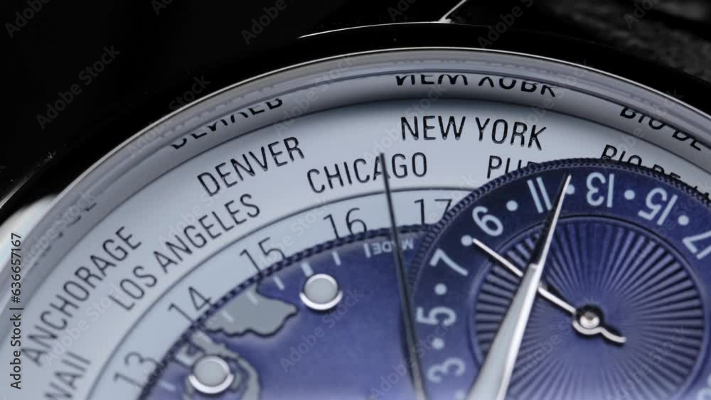 satin on watch face. time zones and countries on the watch face. Extreme closeup of second arrow passing by on blue clock face. Lengthwise view of luxury swiss watch. Closeup real time shot. satin on watch face. time zones and countries on the watch face. Extreme closeup of second arrow passing by on blue clock face. Lengthwise view of luxury swiss watch. Closeup real time shot.