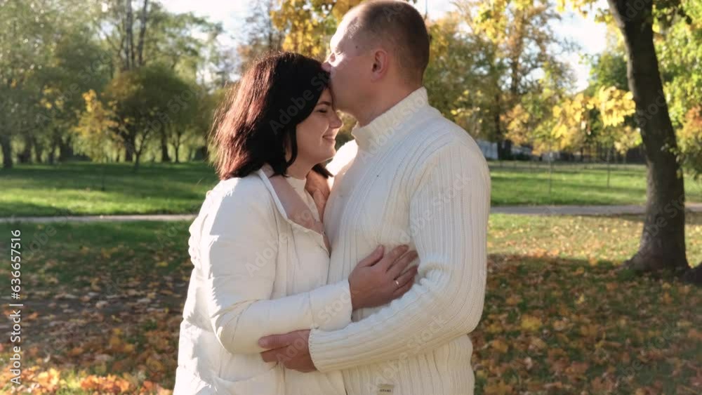 Husband and wife on a walk in the autumn park. The couple looks at each other lovingly. Horizontal video Husband and wife on a walk in the autumn park. The couple looks at each other lovingly. Horizontal video
