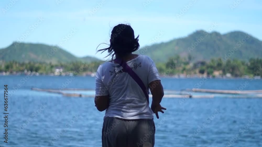 Young adult woman dances exercise at lake shore silhouettes