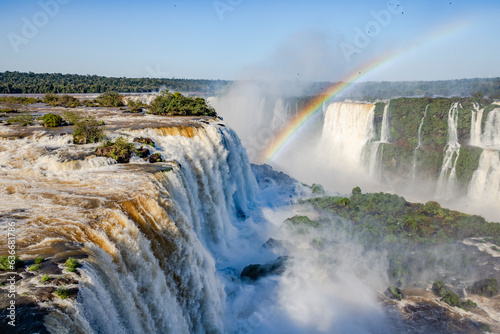 Perfect rainbow over Iguazu Waterfalls, one of the new seven natural wonders of the world in all its beauty viewed from the Brazilian side - traveling South America