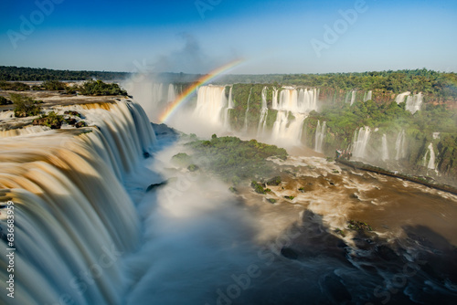 Perfect rainbow over Iguazu Waterfalls, one of the new seven natural wonders of the world in all its beauty viewed from the Brazilian side - traveling South America - long exposure photo