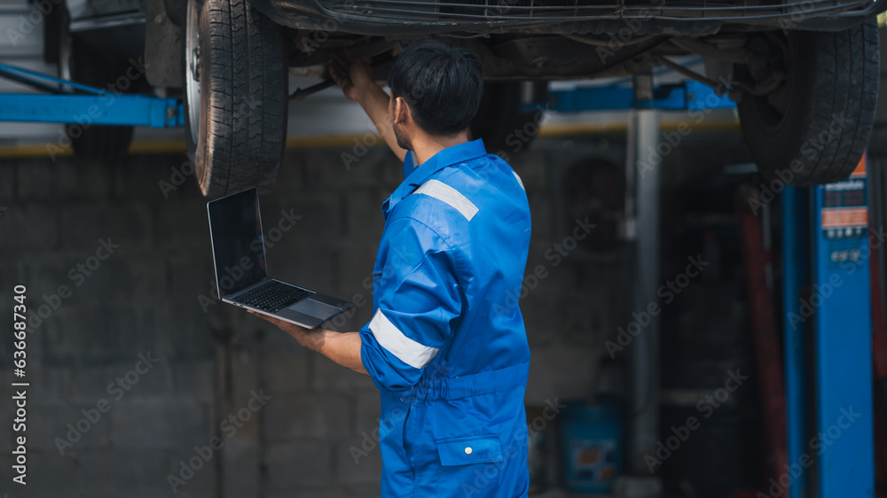 Auto car repair service center. Mechanic examining car suspension