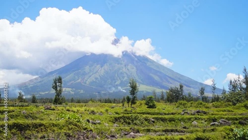 White ash clouds emit from Mayon volcano crater on a clear day photo
