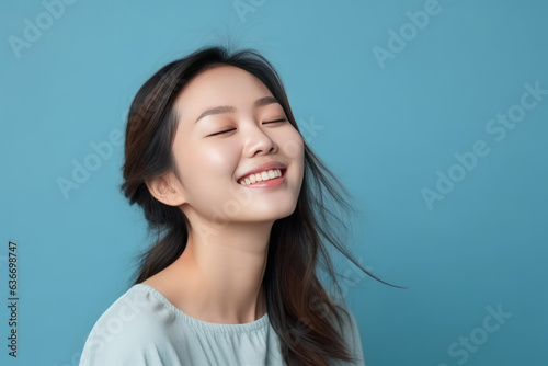 Beautiful Young Happy Thai Woman On Blue Background