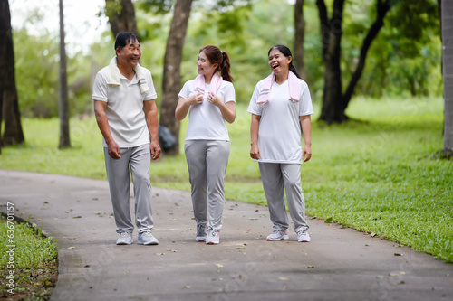 Asian Seniors and Daughter Walking Relax in the Park, Family Bonding in Nature, Seniors and Family Enjoying Exercise and Relaxation in the Green Park, Health Care and Family Bonding Concept