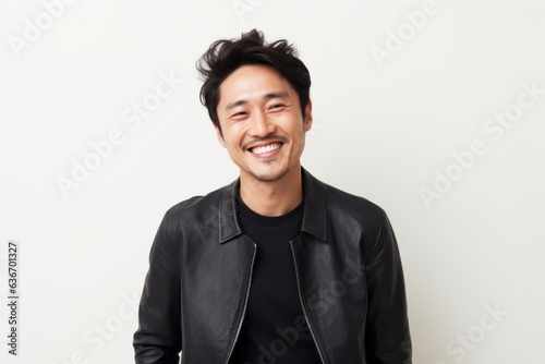 Lifestyle portrait of a Chinese man in his 30s in a white background wearing a chic cardigan