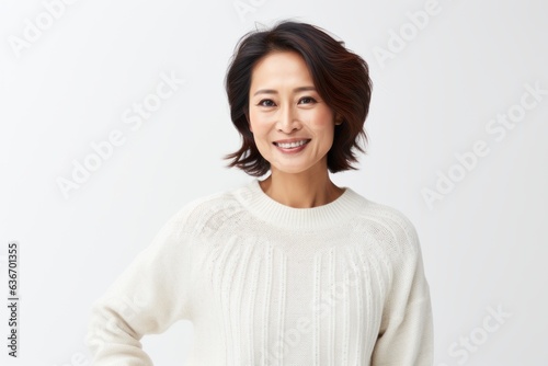 Medium shot portrait of a Chinese woman in her 40s in a white background wearing a cozy sweater