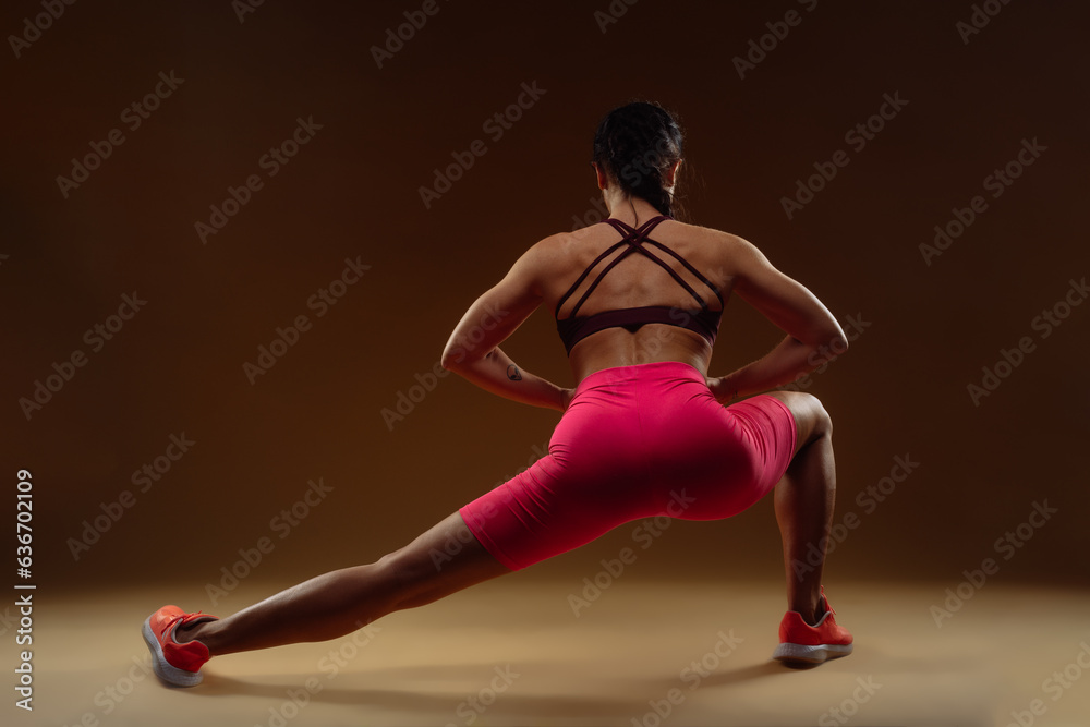 Strong sexy girl exercising with her hands on her spine
