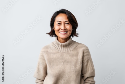 Portrait of a smiling mature asian woman standing isolated over white background