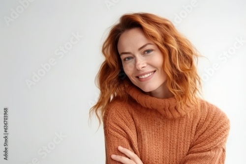 Portrait of attractive young redhead woman with freckles smiling and looking at camera.