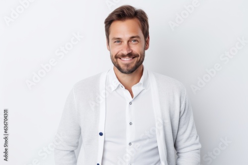 Lifestyle portrait of a Russian man in his 30s in a white background wearing a chic cardigan © Anne-Marie Albrecht
