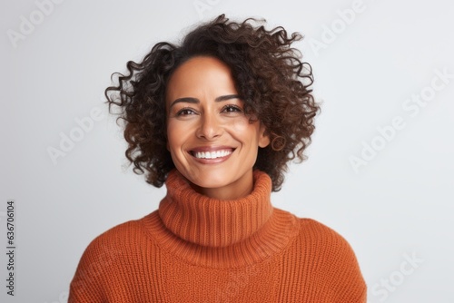 Close-up portrait of a Brazilian woman in her 40s in a white background wearing a cozy sweater