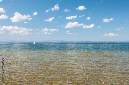 Summer view of lake Uvildy with a sailboat in the background, South Ural, Russia photo