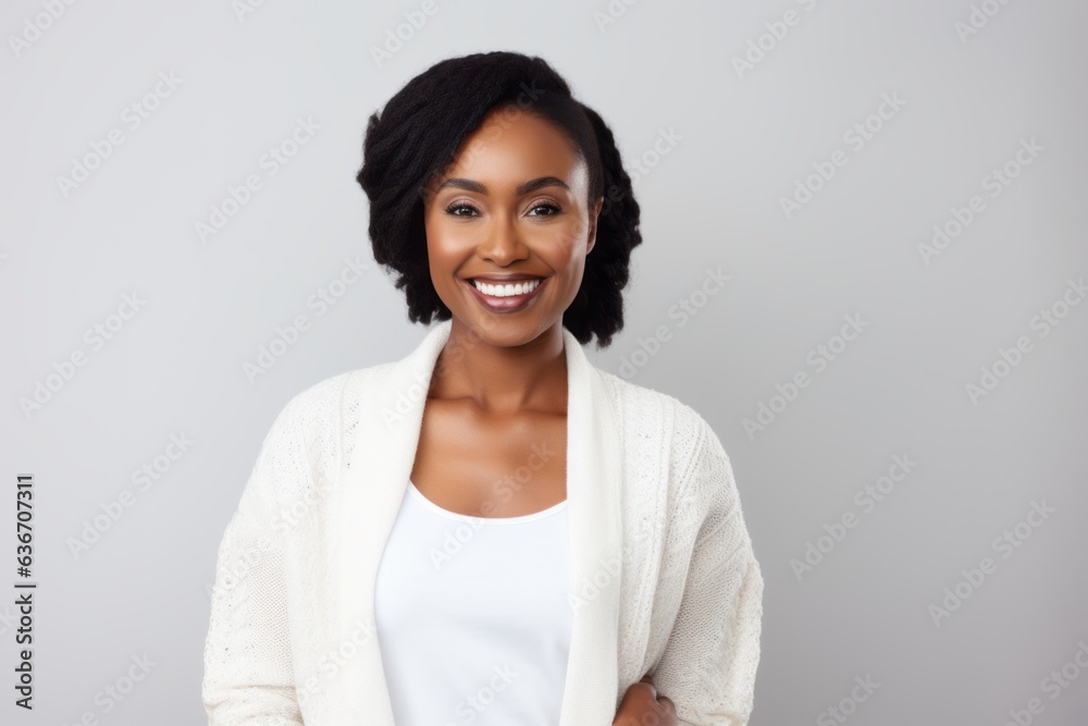 Lifestyle portrait of a Nigerian woman in her 30s in a white background wearing a chic cardigan Lifestyle portrait of a Nigerian woman in her 30s in a white background wearing a chic cardigan