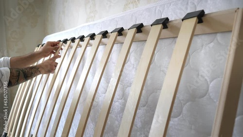 The process of assembling a baby bed with a mattress. Finishing a new bed frame with bed slats. Wood bed base. Bed frame of an orthopedic luxury. Interior structure of furniture.Self-assembly by guide