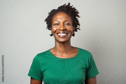 Medium shot portrait of a Nigerian woman in her 40s in a white background wearing a casual t-shirt