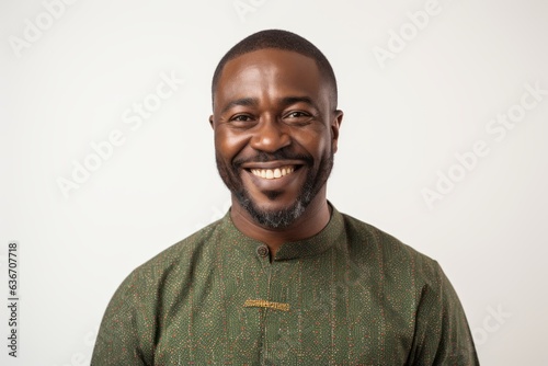 Medium shot portrait of a Nigerian man in his 40s in a white background wearing a chic cardigan