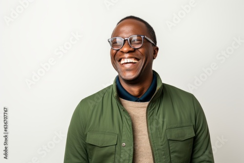 Lifestyle portrait of a Nigerian man in his 40s in a white background wearing a chic cardigan