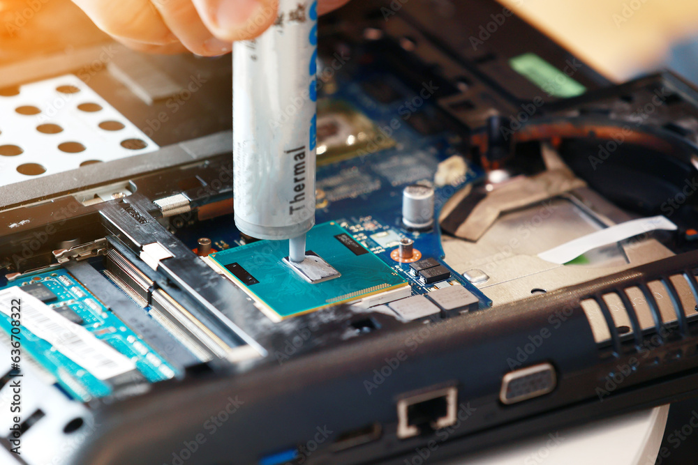 Hand a repairman uses thermal paste syringe apply thermal compound to a