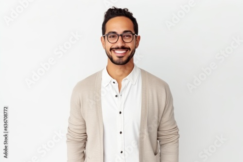 Handsome young man in glasses looking at camera and smiling while standing against white background