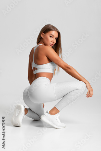 Fitness woman. Athletic girl on the gray background