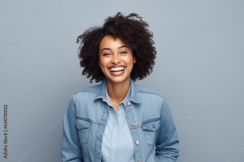 Happy african american woman laughing and looking at camera over grey background Happy african american woman laughing and looking at camera over grey background