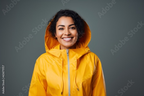 smiling african american woman in yellow raincoat isolated on grey © Anne-Marie Albrecht