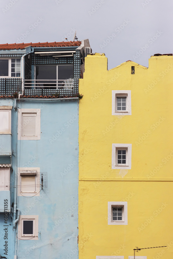 Small windows of a blue and yellow residential building in Europe - the concept of minimalism