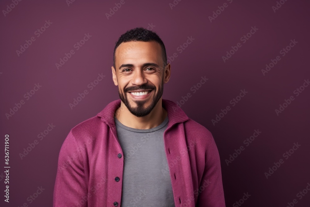 Obraz premium Portrait of a smiling african american man standing against purple background