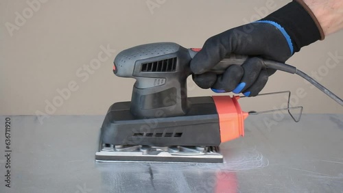 Wallpaper Mural Grinding of aluminum sheet by manual electric machine. Concept production repair at home. View from above. Torontodigital.ca