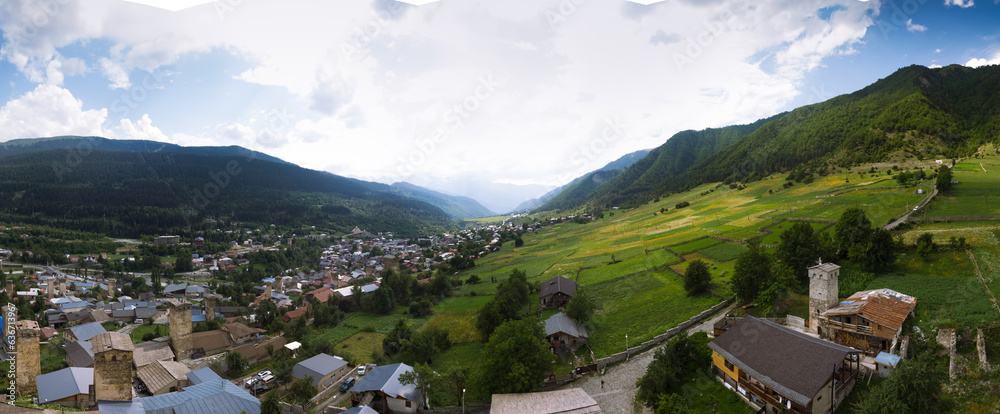 Fototapeta premium A large wide panorama aerial view of Mestia town in Svaneti region of Georgia, located in the Caucasus Mountains. The townlet is dominated by stone defensive towers Mestia