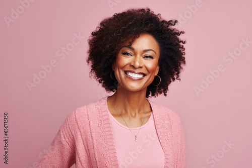 Portrait of a beautiful african american woman smiling on pink background
