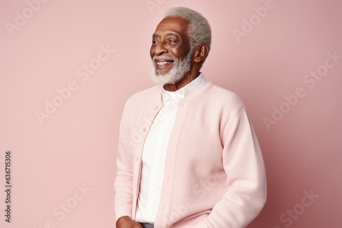 Portrait of a happy senior African American man standing against pink background