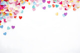 Flat lay of heart shaped confetti and colorful streamers