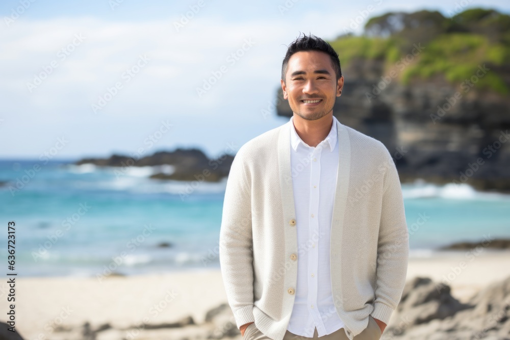 Group portrait of a Indonesian man in his 30s in a beach background wearing a chic cardigan
