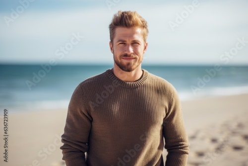 Medium shot portrait of a Russian man in his 30s in a beach background wearing a chic cardigan
