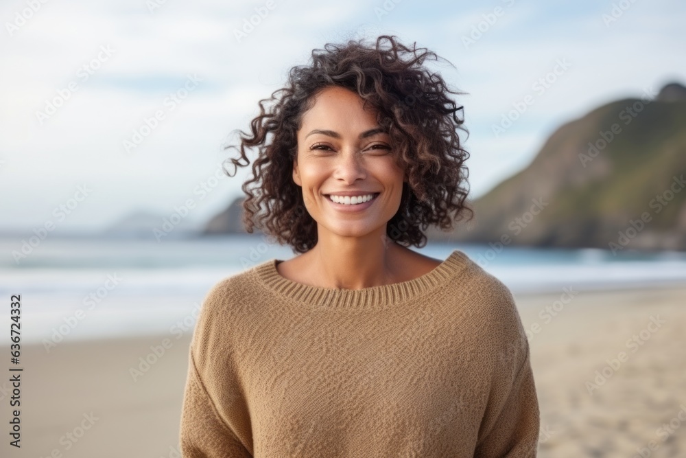 Medium shot portrait of a Brazilian woman in her 40s in a beach background wearing a cozy sweater Medium shot portrait of a Brazilian woman in her 40s in a beach background wearing a cozy sweater