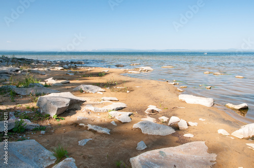 Sandy beach of Uvildy lake covered with huge stones in summer, South Urals, Russian Federation photo